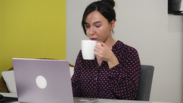 Ung blandras kvinna skriva på bärbar dator när du sitter på hemmakontoret. — Stockvideo