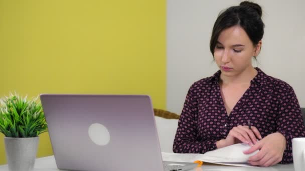 Молода жінка сидить вдома в офісі, спілкуючись через відеодзвінок . — стокове відео