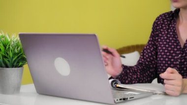 Genç bir melez kadın evde oturuyor ve bir dizüstü bilgisayarla meşgul..