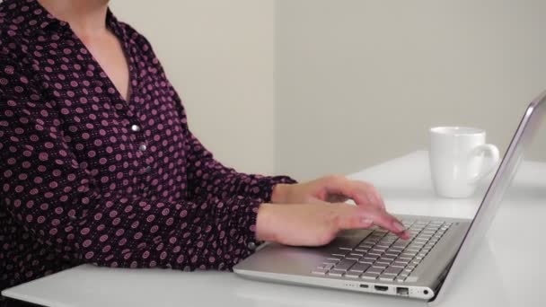 Jeune femme dactylographier sur ordinateur portable tout en étant assis dans le bureau à la maison. — Video
