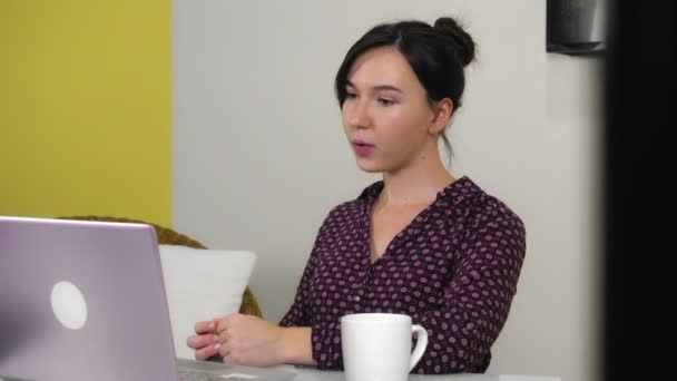 Joven mujer de raza mixta se dedica a la videoconferencia sentado en casa oficina. — Vídeo de stock