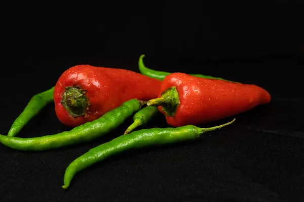 Pimentos Vermelhos Verdes Sobre Fundo Preto Fundo Tecido Preto Dobras — Fotografia de Stock