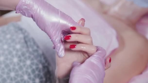 Женщина косметолог делает массаж рук молодой женщине. — стоковое видео