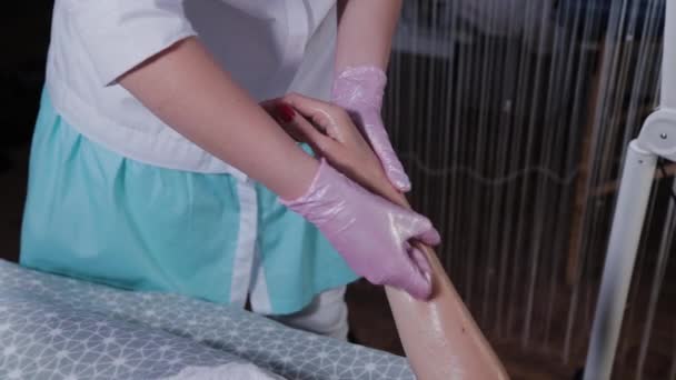 Kosmetikerin macht Handmassage für junge Frau. — Stockvideo
