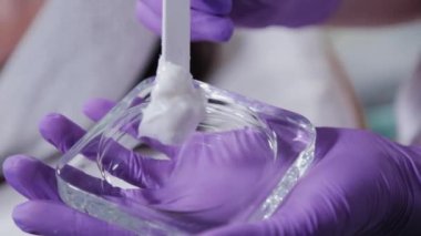 Özel bir spatulayla krem karıştıran kadın güzellik uzmanı..