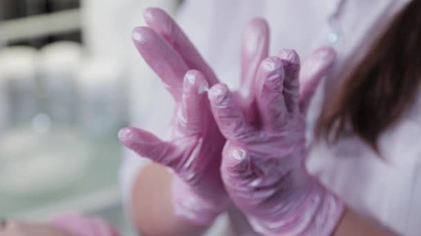 Жінка-косметолог мазає кремом на пальцях . — стокове відео