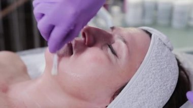 Kadın kozmetik uzmanı, kadınların kozmetoloji kliniğinin müşterileriyle yüz yüze görüşmelerini sağlıyor..