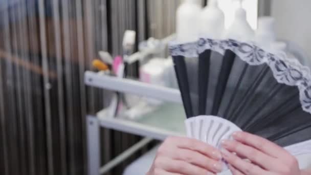 Beautiful woman with a fan on peeling. — Stock Video