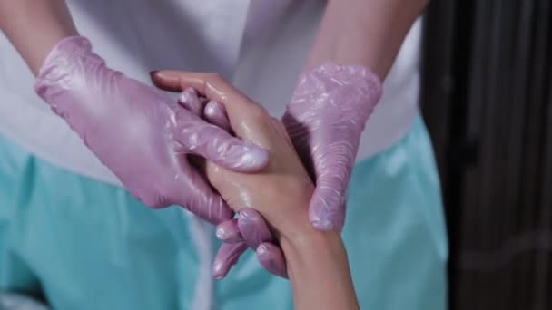 Mulher esteticista fazendo massagem de mão para mulher jovem. — Vídeo de Stock