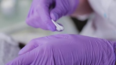 Pamuk tomurcuklarıyla karıştıran kadın güzellik uzmanı elinde özel bir çözüm üretiyor..