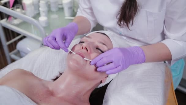 Kvinna kosmetolog gör läppmassage till kvinna. — Stockvideo