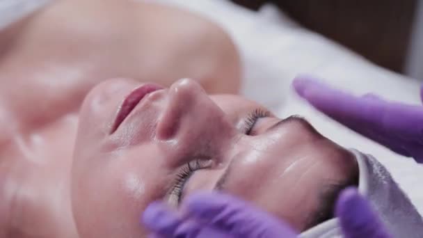 Kosmetolog kobieta masaże kobietom twarz kremem. — Wideo stockowe