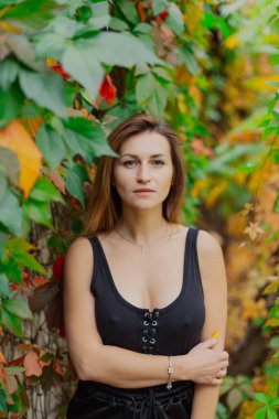 Genç bir kadının sonbahar çalılarındaki güzel portresi..