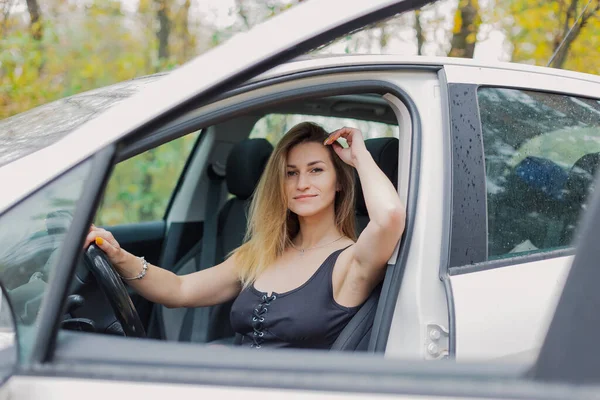 Bella donna in auto bianca in autunno. — Foto Stock