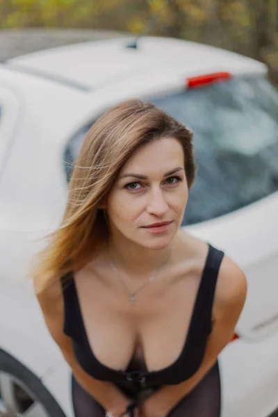 Hermosa mujer junto al coche en el bosque. — Foto de Stock