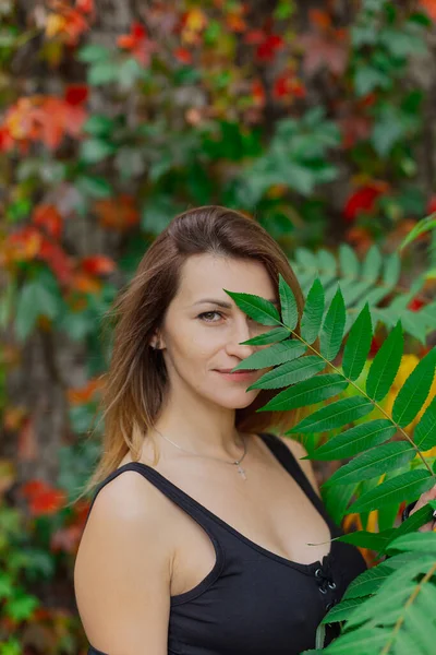 Hermoso retrato de una joven en los arbustos de otoño. — Foto de Stock