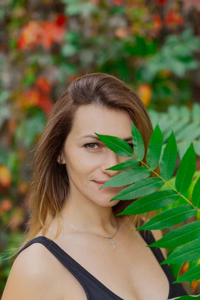 Belo retrato de uma jovem mulher em arbustos de outono. — Fotografia de Stock