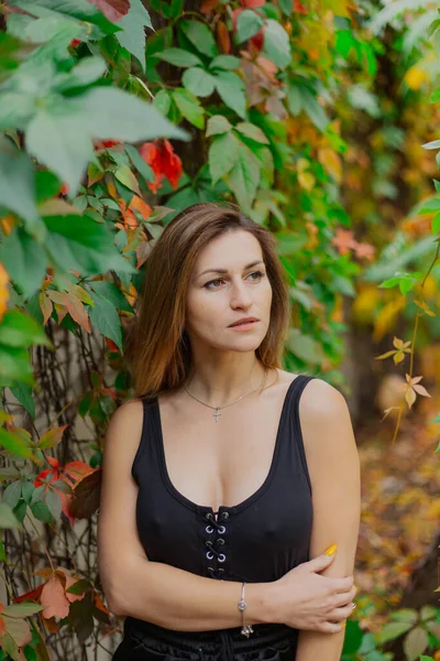 Beautiful portrait of a young woman in autumn bushes. — Stock Photo, Image