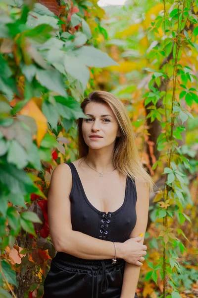 Belo retrato de uma jovem mulher em arbustos de outono. — Fotografia de Stock