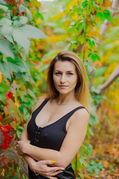 Belo retrato de uma jovem mulher em arbustos de outono. — Fotografia de Stock