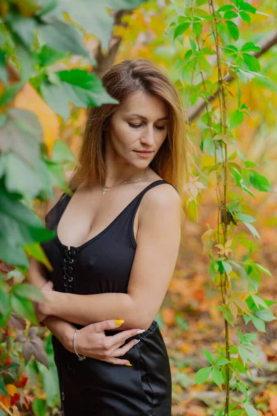 Belo retrato de uma jovem mulher em arbustos de outono. — Fotografia de Stock