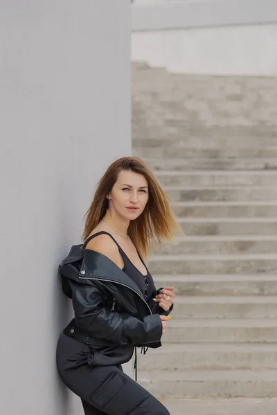 아름다운 젊은 여자가 콘크리트 계단 옆에 서 있다. — 스톡 사진