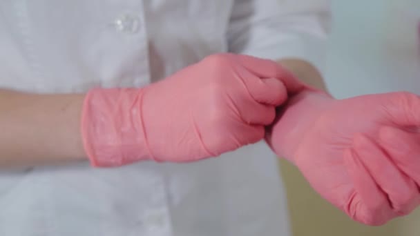 Vrouw schoonheidsspecialiste het aantrekken van rubber handschoenen. — Stockvideo