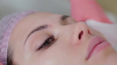 Profesyonel güzellik uzmanı kadın peçetelerle yüz yüze yıkanır..