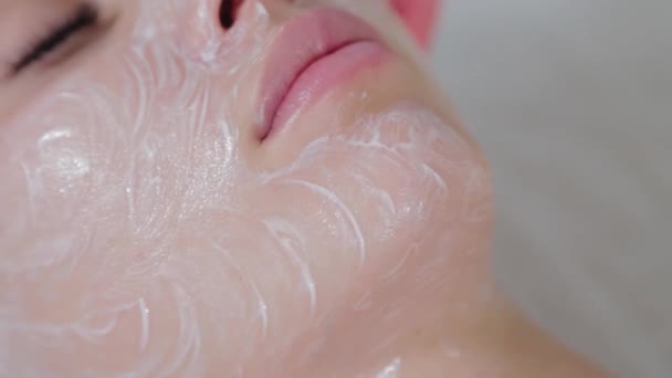 Профессиональный косметолог натирает лицо жидким кремом. — стоковое видео