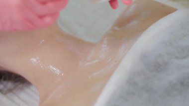 Profesyonel güzellik uzmanı kadın müşteriye fırçayla maske takıyor..