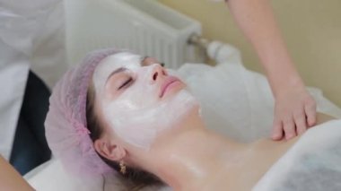 Genç bir kadın için miyoplastik boyun masajı yapan masajcı doktor, yakın çekim görüntüsü. Kozmetoloji kliniğinde güzellik spa prosedürü. Doktor, genç bir kızın boynunu okşayıp okşuyor..