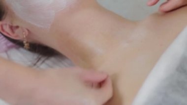 Genç bir kadın için miyoplastik boyun masajı yapan masajcı doktor, yakın çekim görüntüsü. Kozmetoloji kliniğinde güzellik spa prosedürü. Doktor, genç bir kızın boynunu okşayıp okşuyor..
