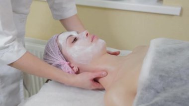 Genç bir kadın için miyoplastik boyun masajı yapan masajcı doktor, yakın çekim görüntüsü. Kozmetoloji kliniğinde güzellik spa prosedürü. Doktor, genç bir kızın boynunu okşayıp okşuyor..