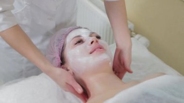 Genç bir kadın için miyoplastik boyun masajı yapan masajcı doktor, yakın çekim görüntüsü. Kozmetoloji kliniğinde güzellik spa prosedürü. Doktor, genç bir kızın boynunu okşayıp okşuyor..