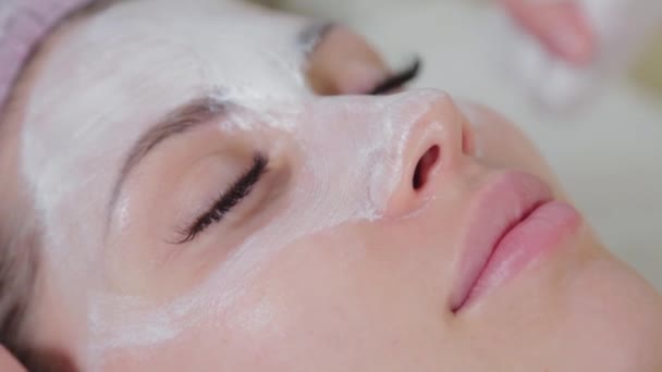 Estetista professionista donna lava il viso al cliente con tovaglioli. — Video Stock