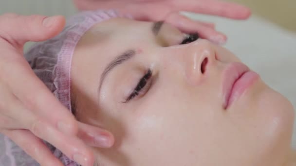 Estetista professionista sfrega il sapone liquido su una faccia di donne. — Video Stock