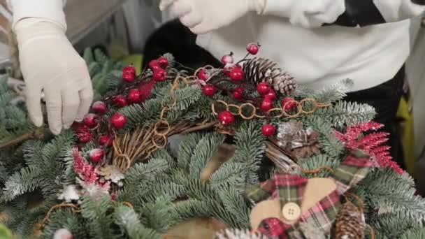 Woman florist makes new year wreaths. — Stock Video