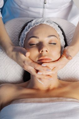 Profesyonel güzellik uzmanı kadın yüz masajı yapıyor..