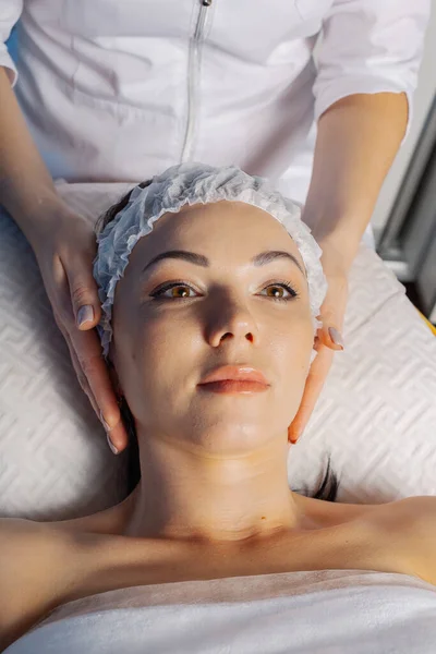 Professional beautician woman straightens hair to a client before a cosmetic procedure. — Φωτογραφία Αρχείου