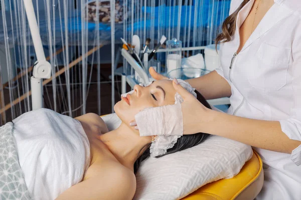 Professional beautician woman washes the clients face with napkins. — Φωτογραφία Αρχείου