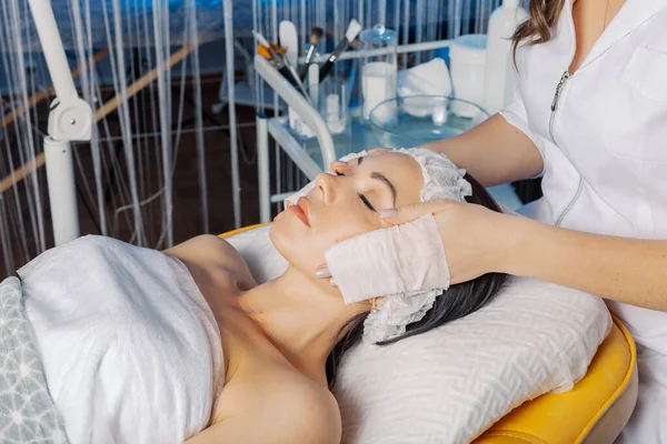 Professional beautician woman washes the clients face with napkins. — Φωτογραφία Αρχείου