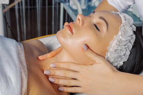 Professionelle Kosmetikerin Frau massiert Gesicht zu Client. — Stockfoto