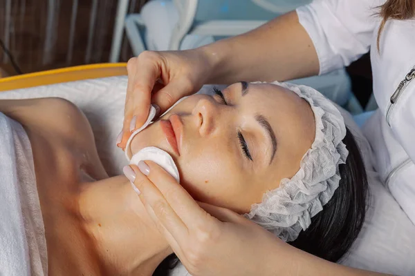 Professional beautician woman wipes face with cotton pads to client. — Φωτογραφία Αρχείου