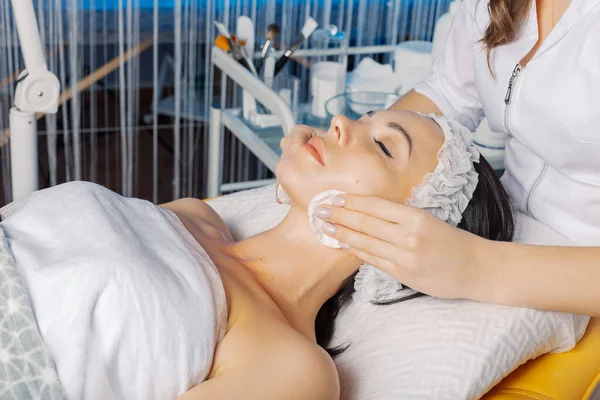 Professional beautician woman wipes face with cotton pads to client. — Φωτογραφία Αρχείου