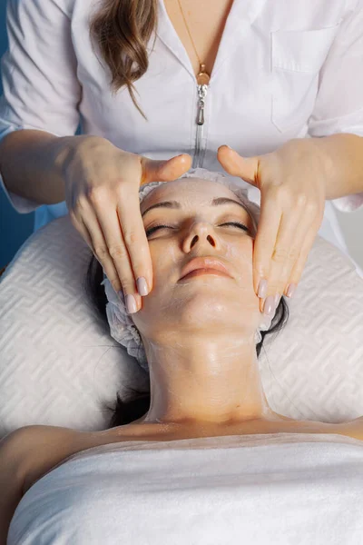 Professional beautician makes a facial massage to a woman. — Φωτογραφία Αρχείου