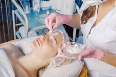 Profesyonel güzellik uzmanı kadınların yüzüne talk pudrası sürüyor..