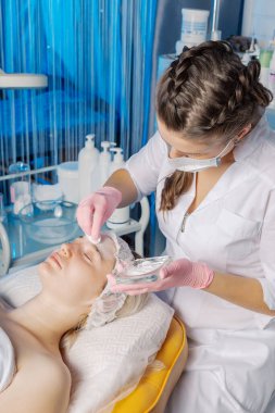 Profesyonel güzellik uzmanı kadınların yüzüne talk pudrası sürüyor..