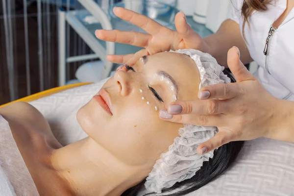 Professional beautician makes a facial massage to a woman. — Φωτογραφία Αρχείου