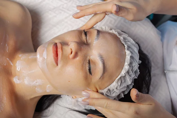 Professionelle Kosmetikerin macht einer Frau eine Gesichtsmassage. — Stockfoto