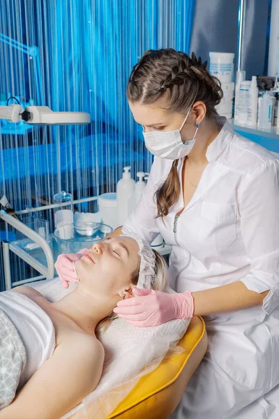 Esteticista profesional hace un masaje facial a una mujer. —  Fotos de Stock